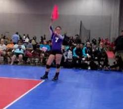 Volleyball line judge signaling ball hit the antenna